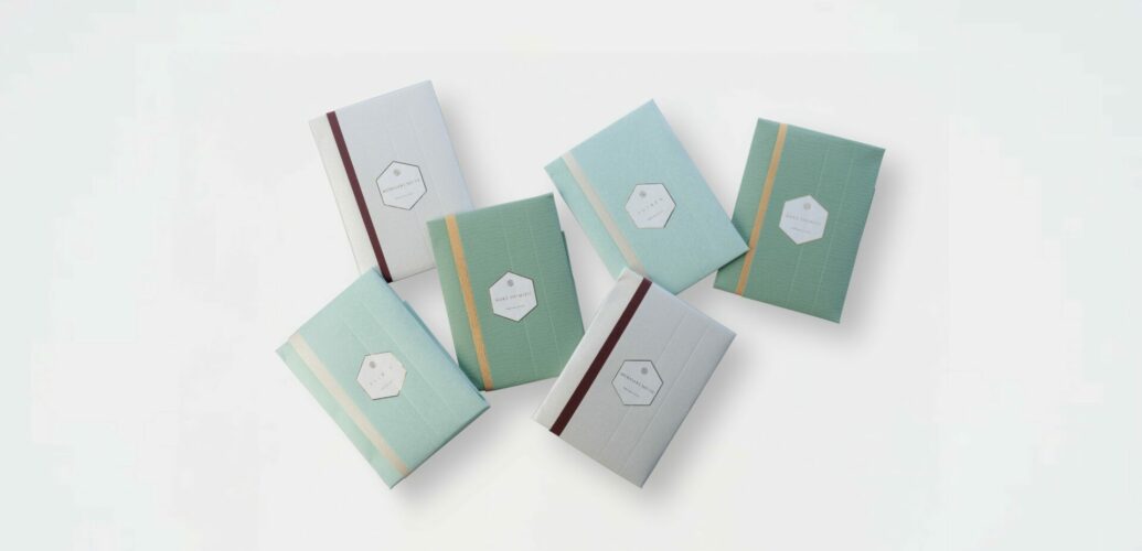 たとう和紙で包んだパルファンサトリのパフューム バスソルトが色違いで並んでいる写真