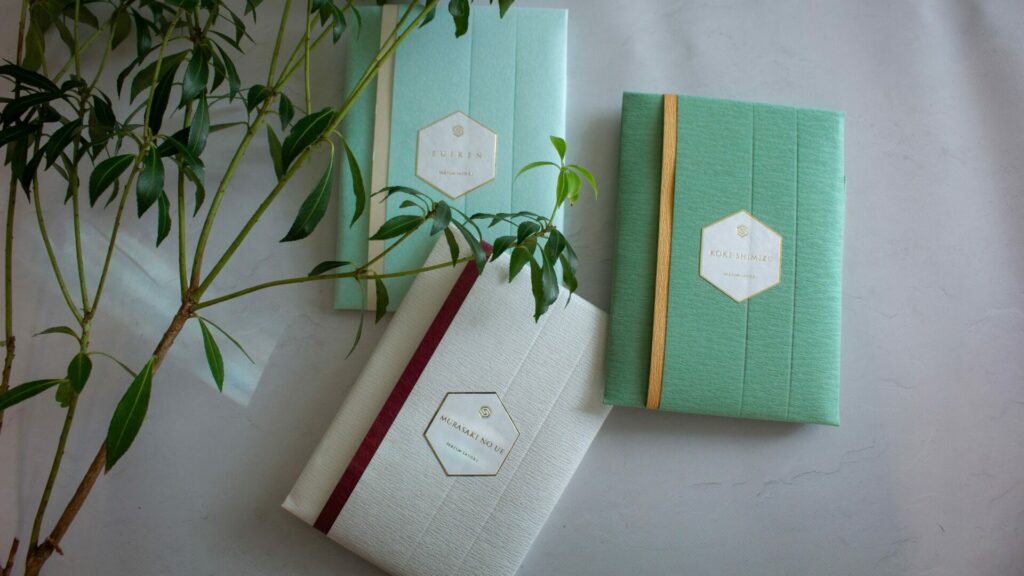 グリーンの枝葉とともに並べられた「睡蓮」「苔清水」「紫の上」3種の パフューム バスソルト 