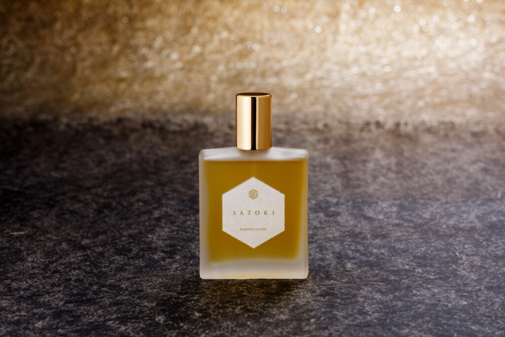 The SATORI bottle illuminated in soft light, expressing quiet depth and refined harmony.