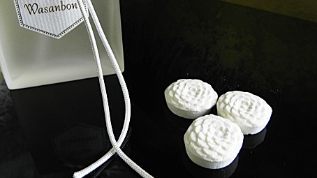 2013年、オリジナルのオードパルファン「WASANBON」のボトルと、白い和三盆の落雁を並べたイメージ。