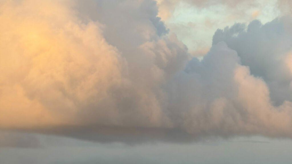 海と空の境界が溶け合う夕暮れ。香りと光が交わる象徴的なイメージ。