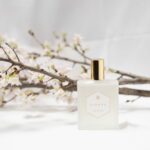 パルファンサトリの桜の香水ボトルと本物の桜の枝の写真