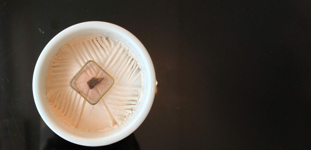 Agarwood incense heating gently in an incense burner, releasing a slow, quiet fragrance