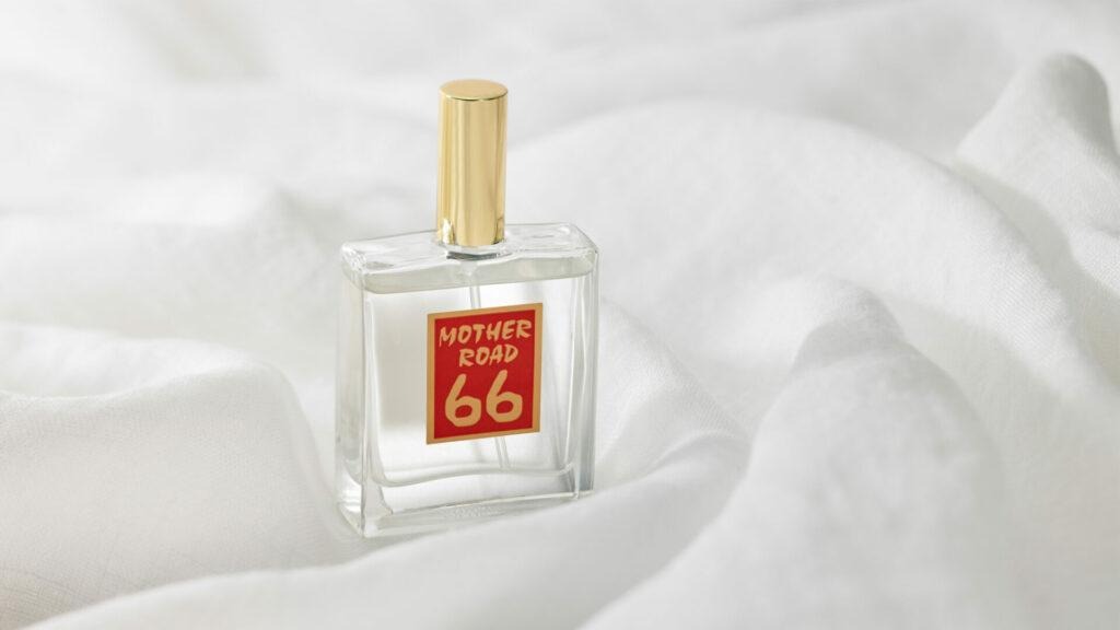 A close-up shot of the classic MOTHER ROAD 66 perfume bottle featuring its iconic retro square red label.A close-up shot of the classic MOTHER ROAD 66 perfume bottle featuring its iconic retro square red label.