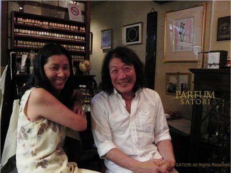A warm photograph of perfumer Satori Osawa smiling alongside musician Toru Yazawa during his visit to the atelier.